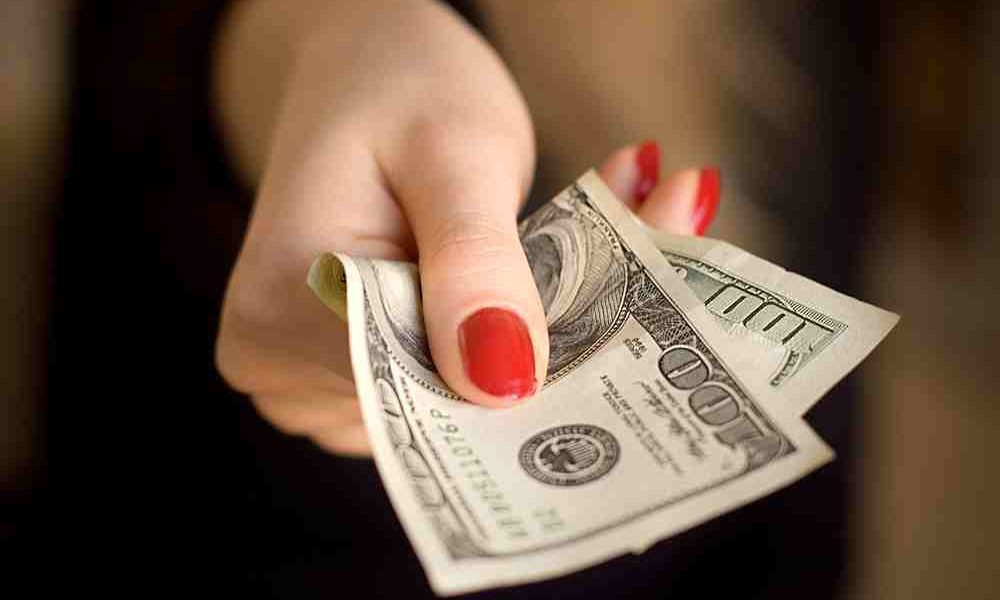 women handing off money